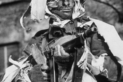 A member of the London Home Guard demonstrates the use of old wallpaper as camouflage (1942)