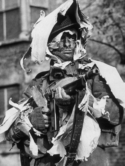 A member of the London Home Guard demonstrates the use of old wallpaper as camouflage (1942)