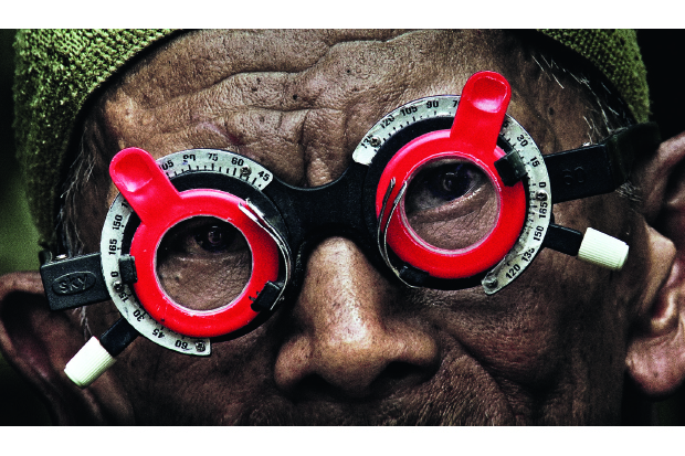 Adi Rukun tests the eyes of one of the men who killed his brother